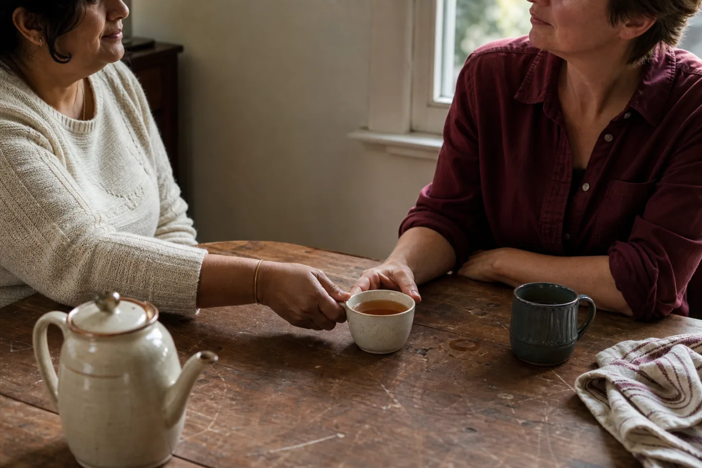 One person offering another a cup of tea during a partner conversation about HSV dating.